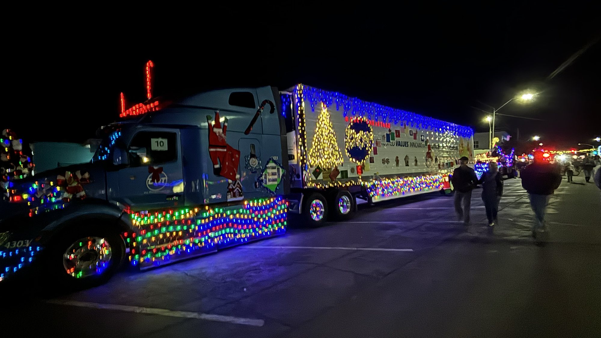A semi truck outlined in lights moving down Beale Street at night during the Street of Lights parade